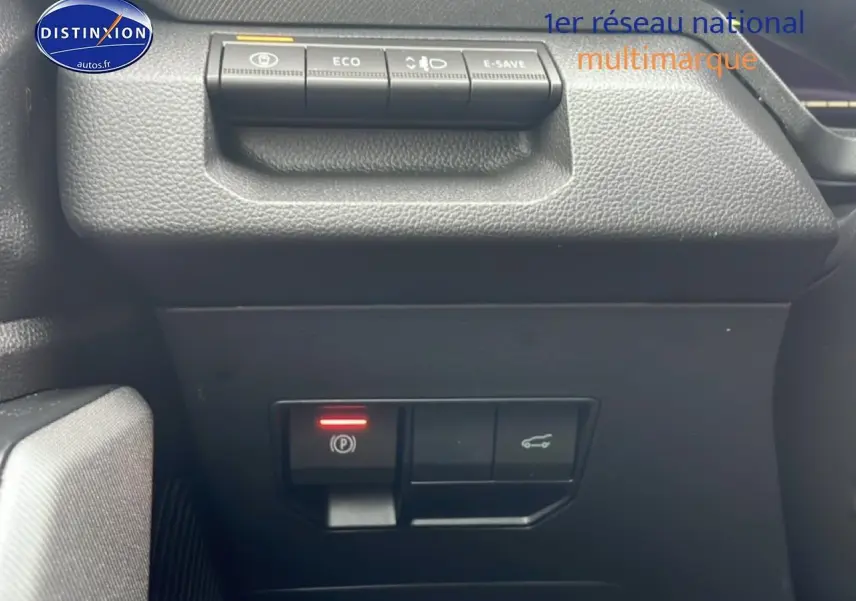 Gros plan sur les commandes de la planche de bord du Dacia Bigster noir, avec bouton frein à main électronique allumé.