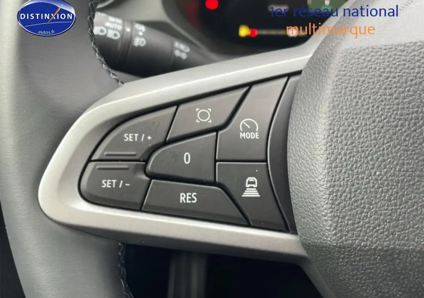 Gros plan sur les commandes au volant du Dacia Bigster 1.8 hybrid 155 Journey, boutons noirs avec cadre argenté.