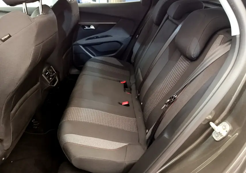 Vue côté droit sur la banquette arrière noire à motifs du Peugeot 3008 gris foncé, avec ceinture et appuie-têtes visibles.