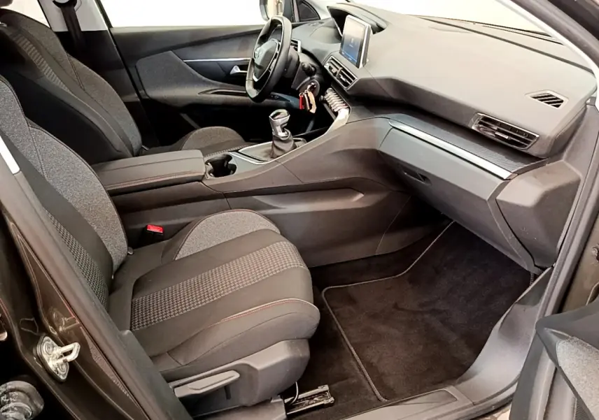Intérieur avant droit du Peugeot 3008 gris foncé 2020, montrant sièges tissu, tableau de bord et écran tactile central.
