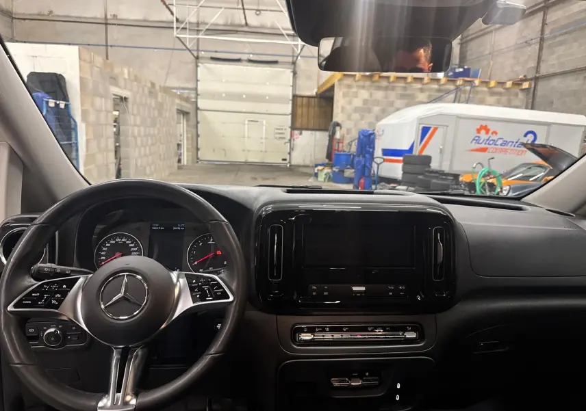 Vue intérieure du tableau de bord et volant cuir noir d'un Mercedes Vito Mixto 2025, avec écran central éteint.