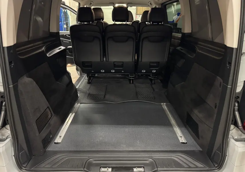 Vue arrière intérieure du Mercedes Vito Mixto gris Alpin, montrant l'espace de chargement et la banquette 3 places en cuir noir.