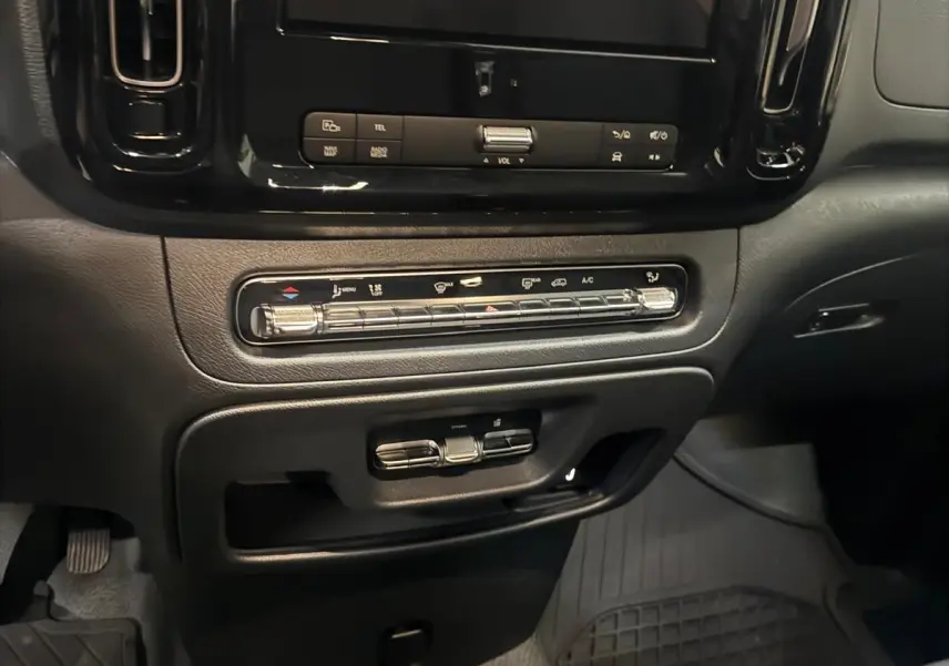 Vue rapprochée du tableau de bord noir du Mercedes Vito Mixto 2025, mettant en valeur l'écran tactile et les commandes de climatisation.