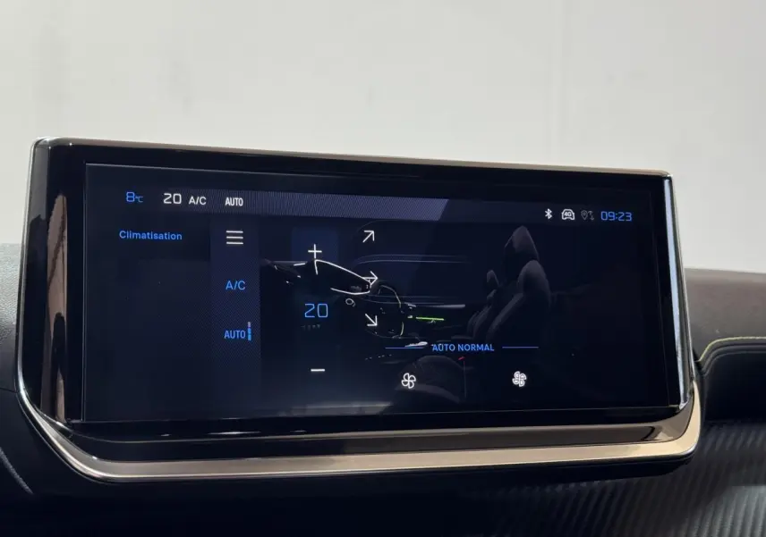 Écran tactile central affichant la climatisation à 20°C dans l'habitacle d'une Peugeot 208 Hybrid gris clair.