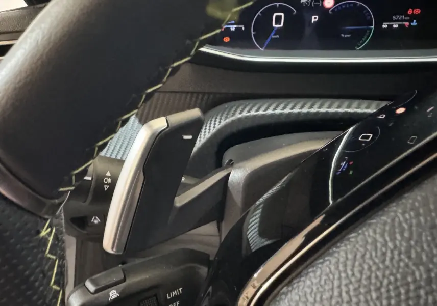 Gros plan sur le volant cuir et le combiné numérique de la Peugeot 208 Hybrid 136 eDCS6 GT, affichage multifonctions lumineux.