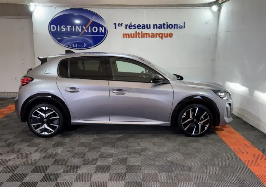 Profil droit de la Peugeot 208 Hybrid 136 eDCS6 GT gris clair, avec jantes noires et détails modernes visibles.