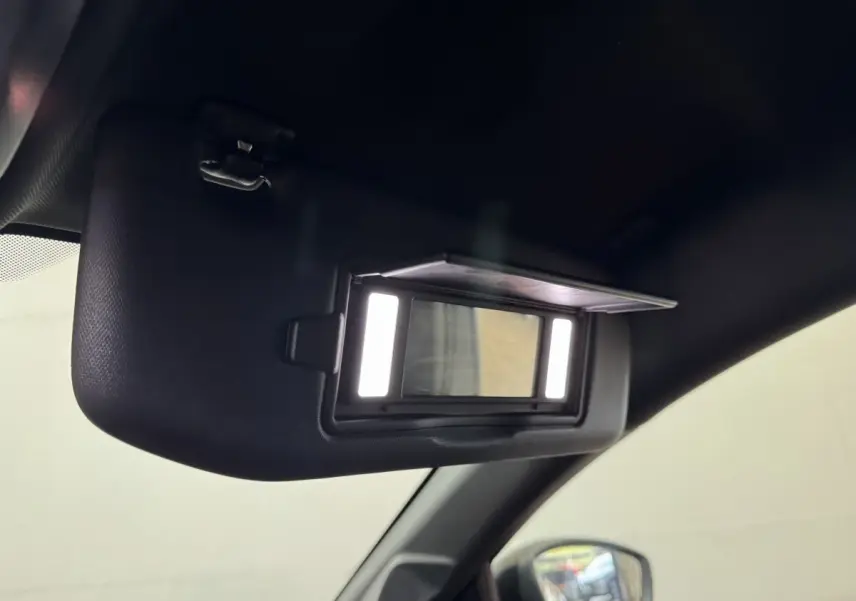 Détail intérieur du pare-soleil avec miroir éclairé sur Peugeot 208 Hybrid 136 eDCS6 GT, vue côté conducteur.