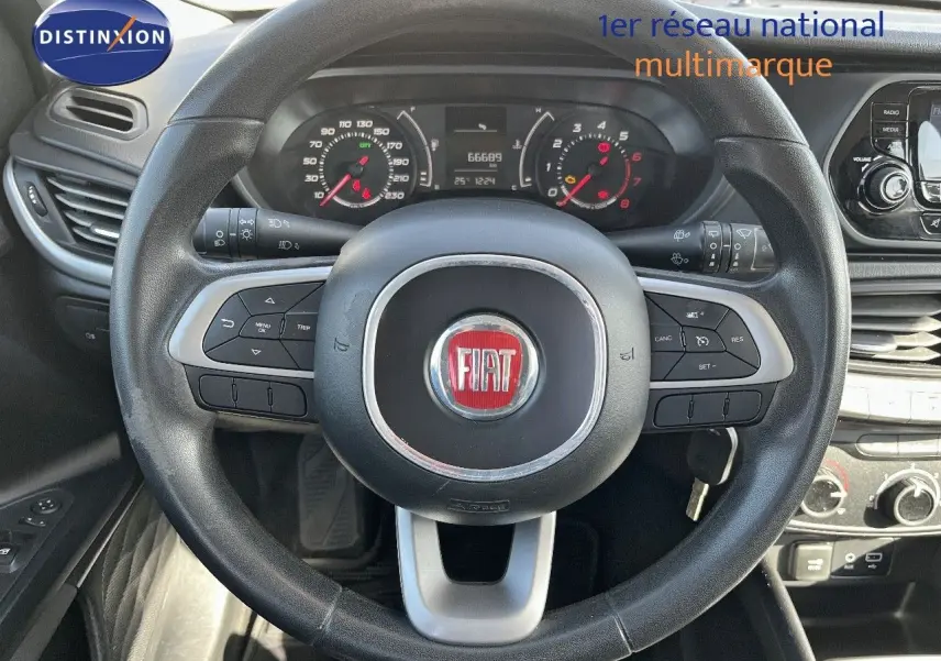 Vue intérieure centrée sur le volant noir de la Fiat Tipo 5 portes 2018, avec tableau de bord et commandes visibles.
