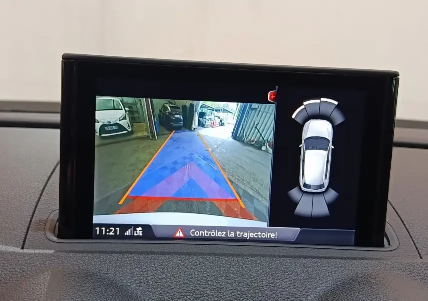 Écran tactile intérieur montrant la caméra de recul et l’aide au stationnement d’un Audi A3 blanc.