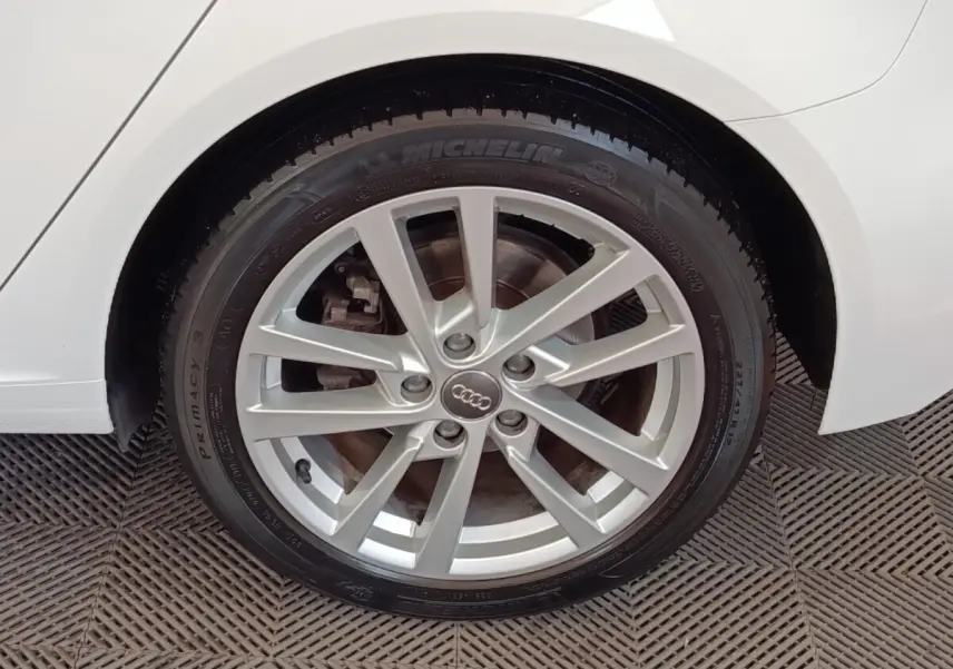 Gros plan sur la roue arrière droite d'une Audi A3 blanche, avec jante alliage argentée et pneu Michelin.