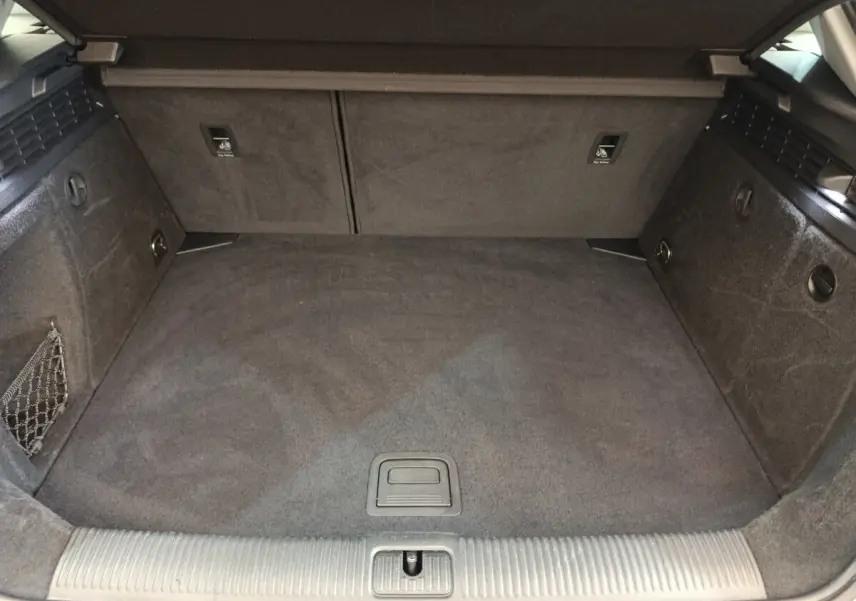 Vue intérieure du coffre spacieux et propre de l'Audi A3 35 TDI 150 S tronic Business Line, revêtement gris foncé.