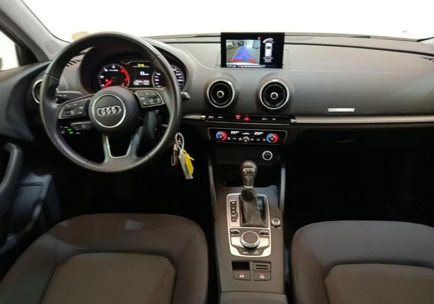 Vue intérieure avant de l'Audi A3 35 TDI 2020, tableau de bord noir avec volant cuir multifonctions et écran tactile central.