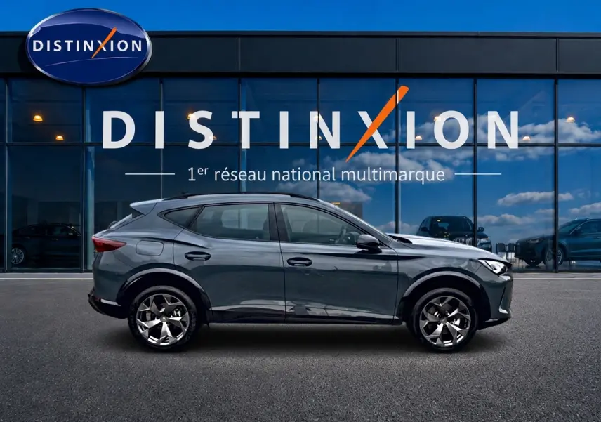Vue latérale droite d'un CUPRA Formentor bleu fjord 2026 avec jantes 18 pouces devant une vitrine Distinxion.