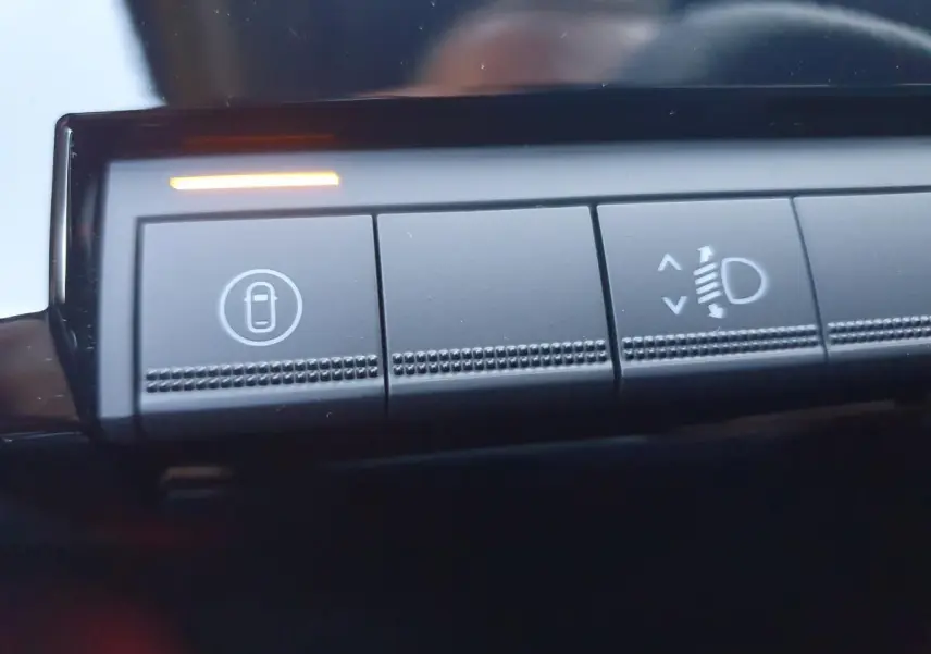 Gros plan sur les boutons de commande intérieurs de la Renault R5 E-TECH jaune Pop, avec témoin lumineux orange allumé.