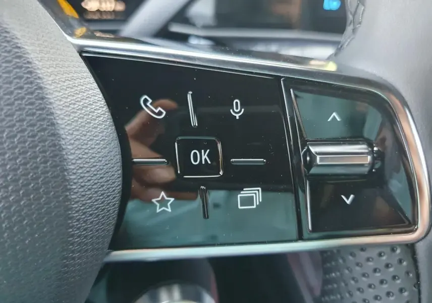 Gros plan sur les commandes multifonctions noires à droite du volant dans l’habitacle de la Renault R5 E-TECH jaune Pop.