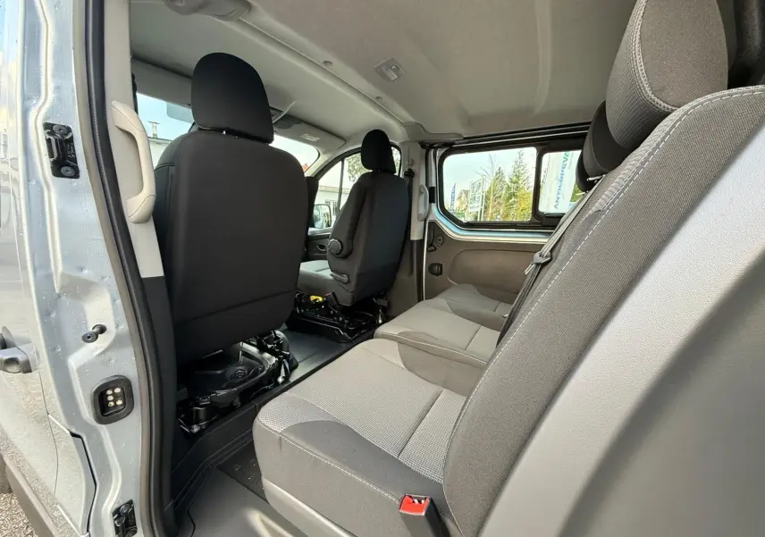 Gros plan sur l'avant droit gris Highland du Renault Trafic cabine approfondie 2025 avec calandre noire et phares LED.