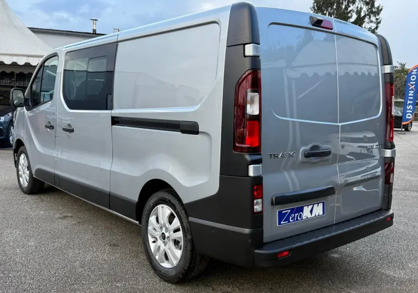 Vue arrière d'un Renault Trafic cabine approfondie gris Highland avec portes battantes et feux arrière verticaux.