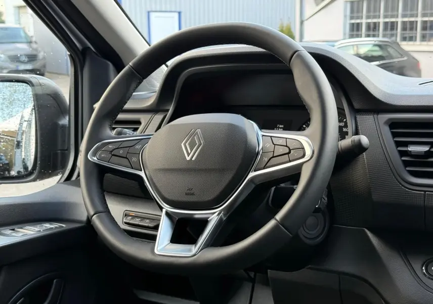 Renault Trafic cabine approfondie gris Highland en 3/4 avant droit, avec calandre noire et jantes argentées.