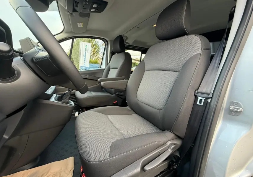 Vue 3/4 arrière droite du Renault Trafic cabine approfondie gris Highland avec hayon arrière et jantes alliage.