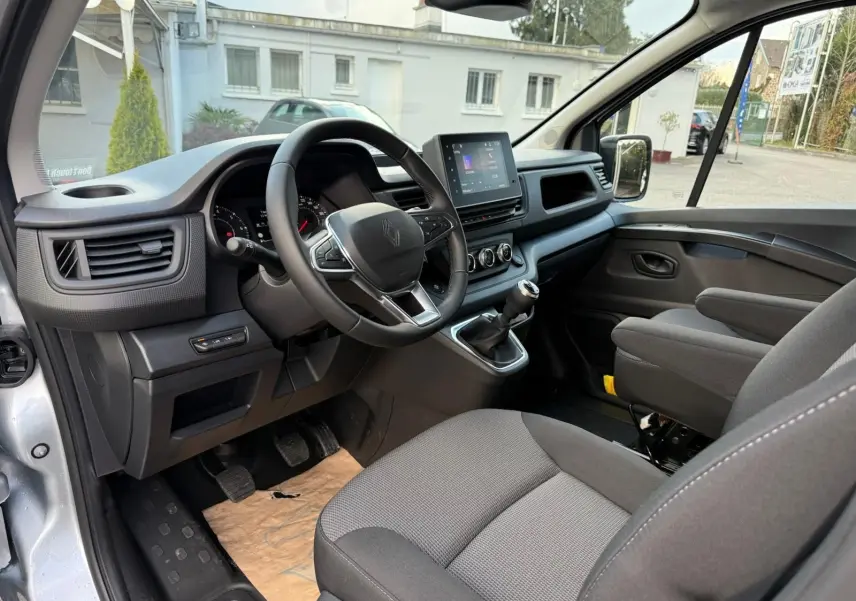 Renault Trafic cabine approfondie gris Highland vu en 3/4 avant droit, avec calandre noire et feux LED modernes.