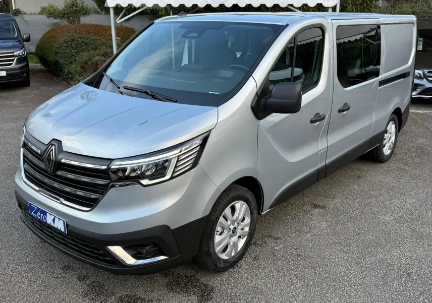 Vue 3/4 avant droite d'un Renault Trafic cabine approfondie gris Highland avec calandre noire et jantes acier.