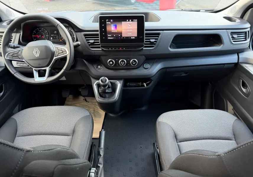 Vue 3/4 avant d’un Renault Trafic cabine approfondie gris Highland 2025 avec calandre noire et feux LED distinctifs.