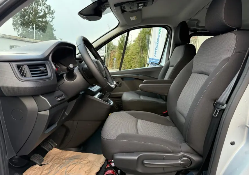 Renault Trafic cabine approfondie gris Highland vu de profil côté gauche, avec fenêtres teintées et jantes alliage.