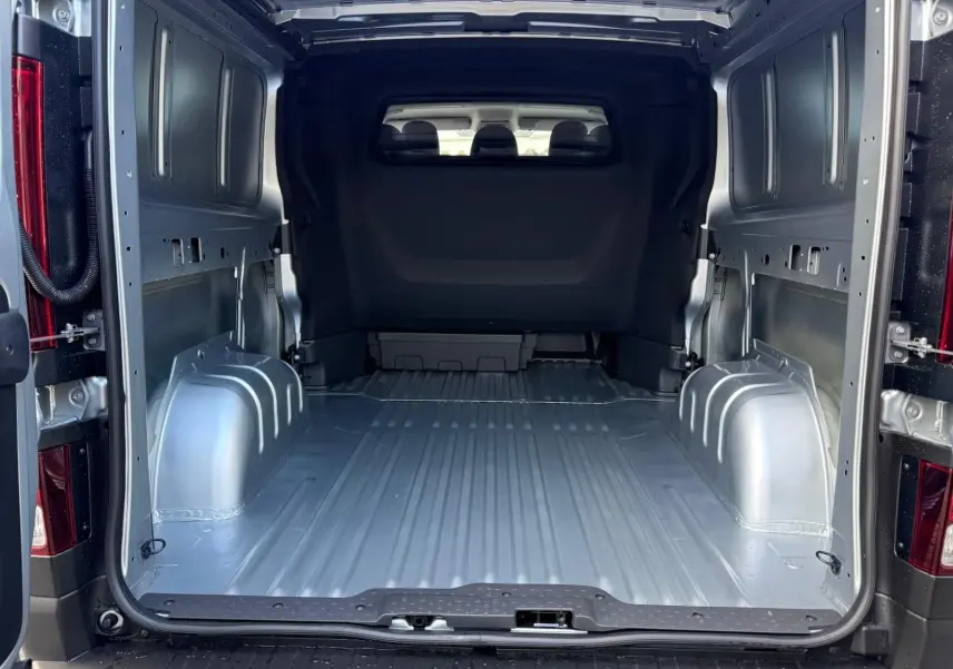 Intérieur avant du Renault Trafic cabine approfondie 2025, vue du poste de conduite avec tableau de bord et sièges gris.
