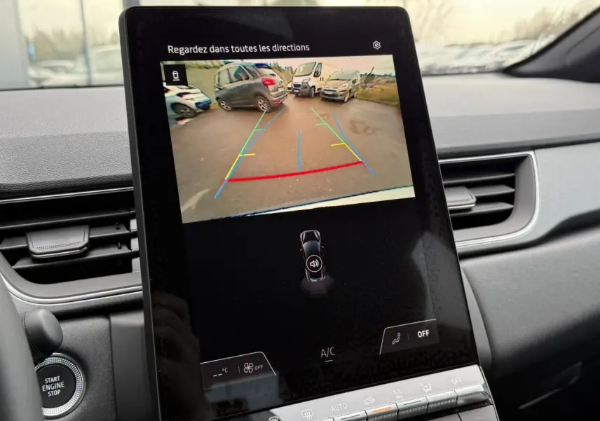 Écran central du Renault Captur 2025 affichant la caméra de recul avec lignes de guidage colorées, intérieur gris.