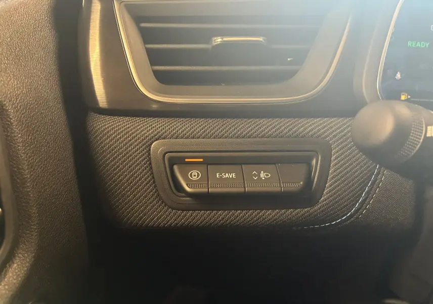 Gros plan sur les commandes E-SAVE et réglage des phares sur la planche de bord du Renault Captur noir étoile 2025.