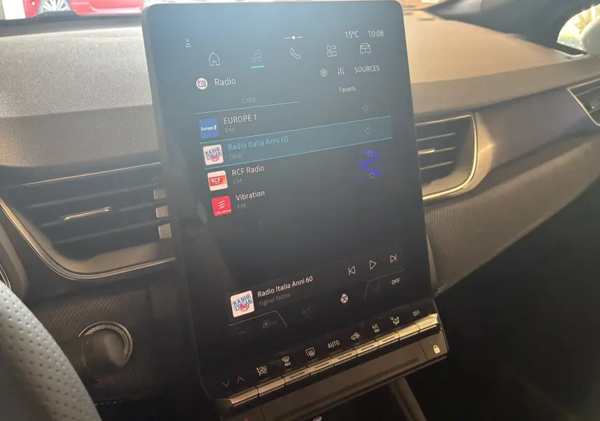 Vue intérieure du tableau de bord du Renault Captur E-Tech hybride 2025, écran tactile central affichant les radios disponibles.