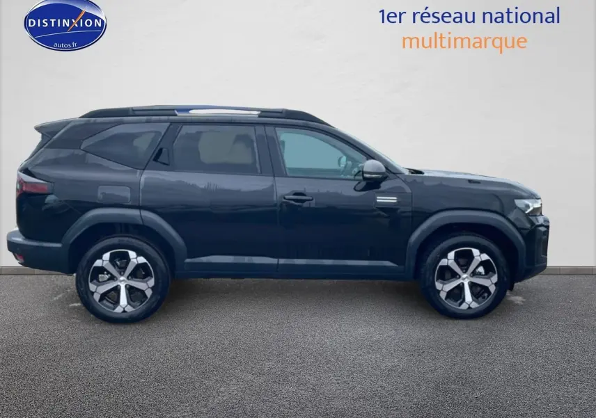 Profil droit du SUV Dacia Bigster noir 2025 avec jantes alliage 18 pouces et barres de toit.