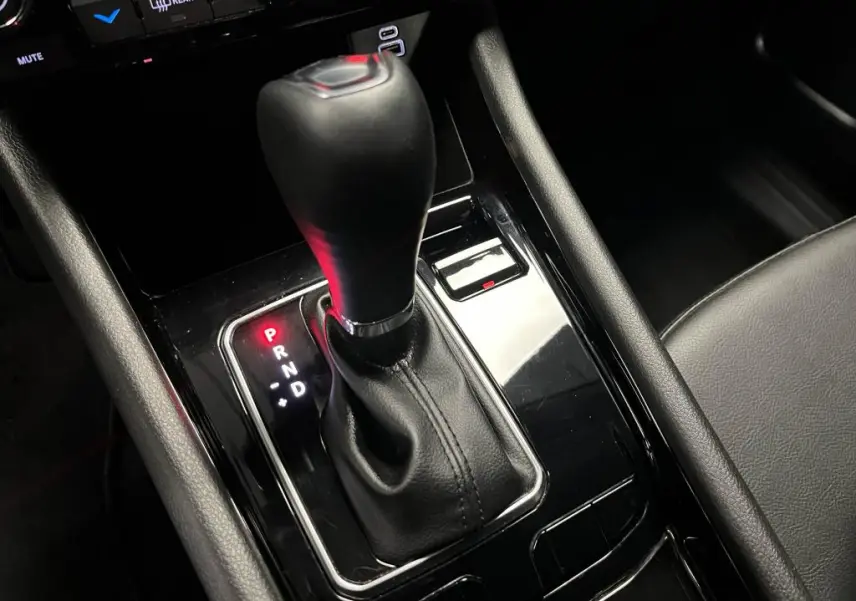 Gros plan sur le levier de vitesses automatique noir brillant de la Jeep Compass 2024, avec indication P allumée en rouge.