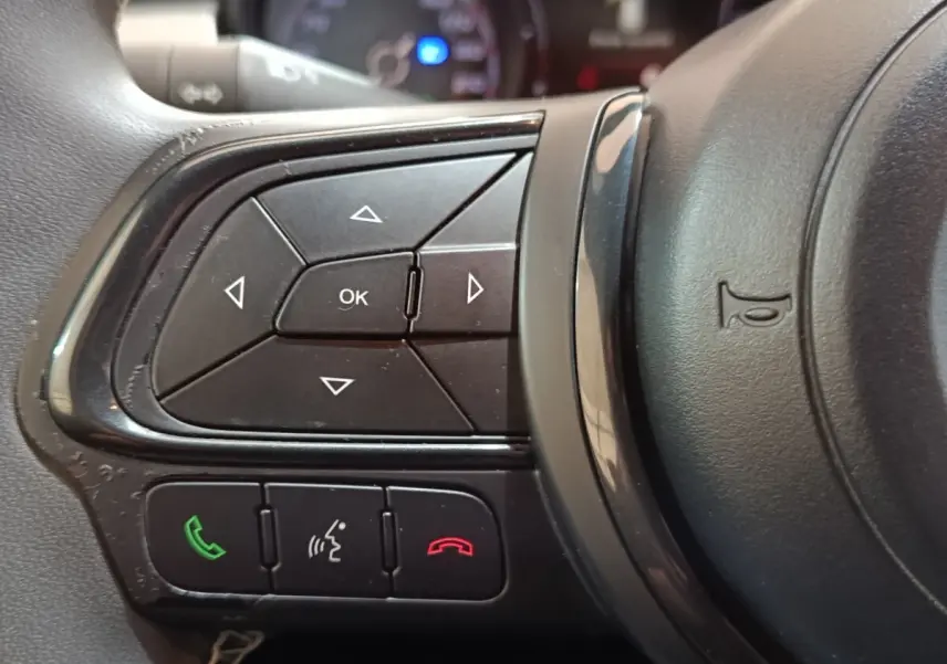 Gros plan sur les commandes multifonctions noires à gauche du volant de la FIAT 500X noir, version 2021.