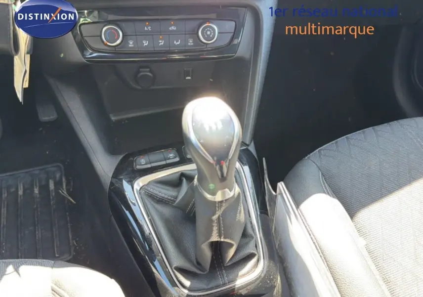 Gros plan sur la console centrale de l’Opel Corsa 1.2 75 Elegance 2022, levier de vitesse manuel et commandes climatisation.