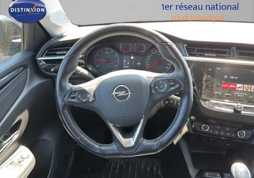 Vue intérieure centrée sur le volant cuir d'une Opel Corsa 1.2 75 Elegance avec tableau de bord et écran tactile.