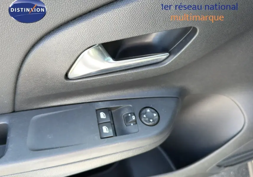 Gros plan sur la commande des vitres et rétroviseurs côté gauche de la porte intérieure d’une Opel Corsa gris quartz métal.