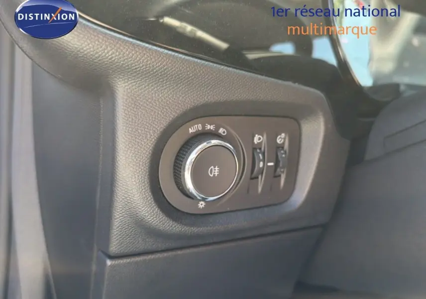 Gros plan sur le bouton de commande des phares à gauche du volant dans l’Opel Corsa gris quartz métal 2022.