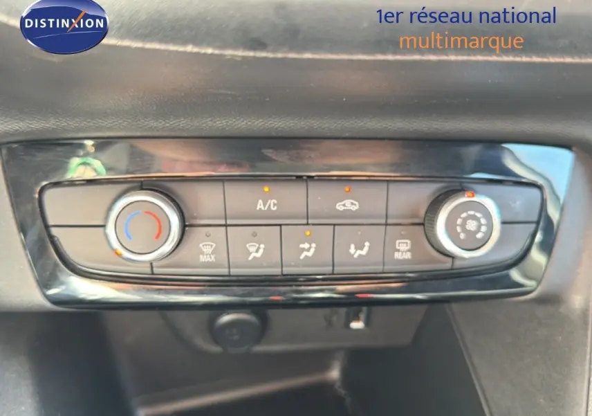 Gros plan sur la console de climatisation d’une Opel Corsa gris quartz metal, avec commandes manuelles et affichage des fonctions actives.