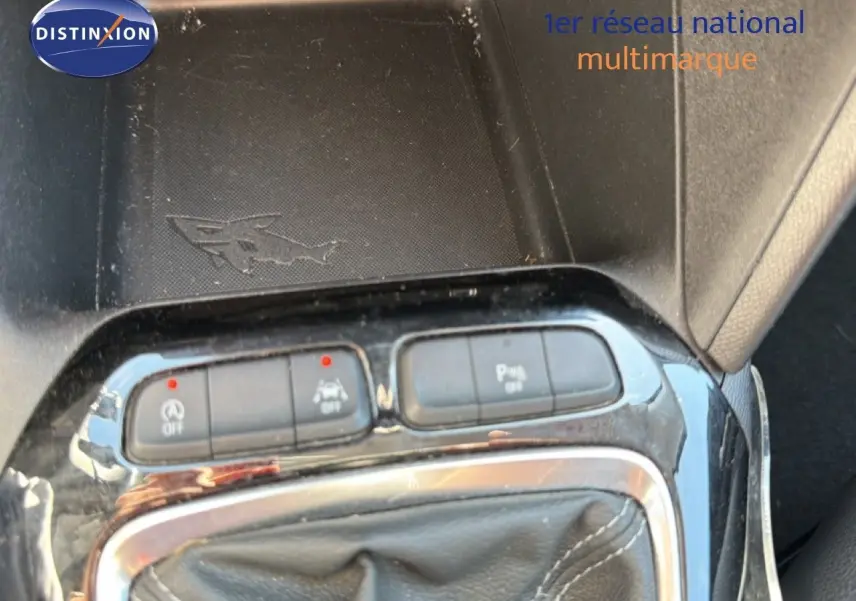 Gros plan sur la console centrale de l’Opel Corsa gris quartz, montrant les boutons de contrôle et le soufflet de levier de vitesse cuir noir.