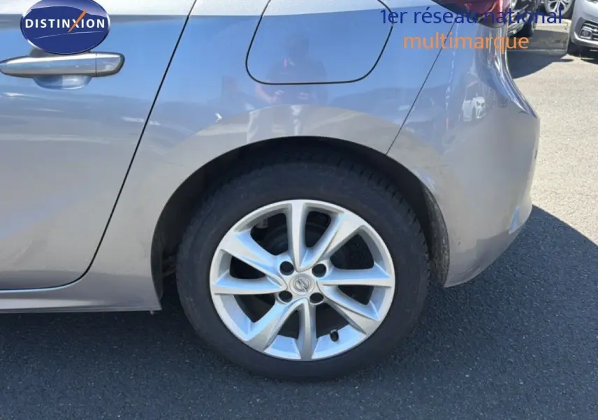 Vue latérale droite en gros plan sur la roue arrière et la portière gris quartz métallisé d'une Opel Corsa 2022.