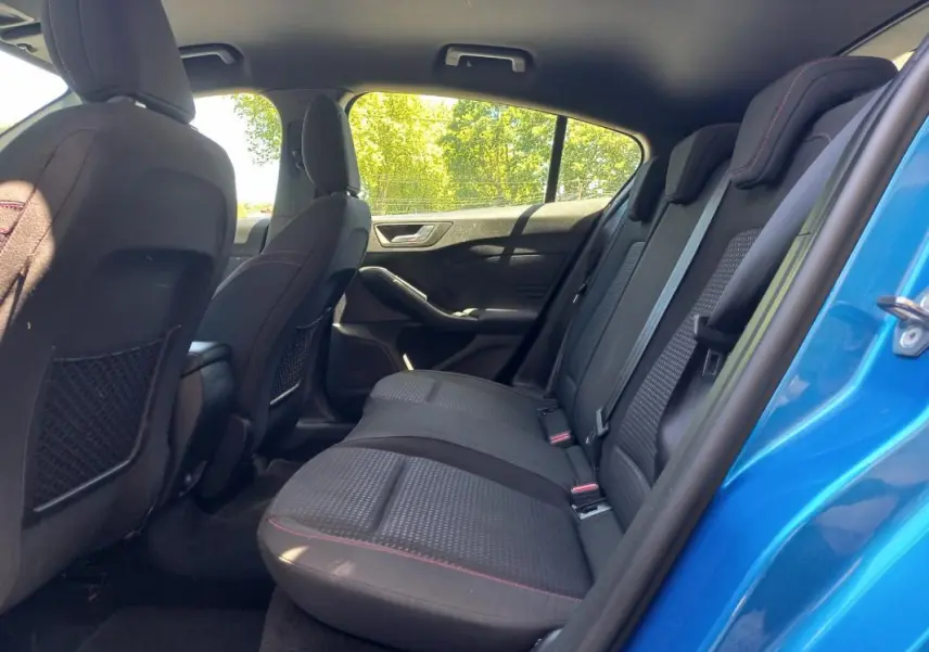 Vue intérieure arrière côté droit de la Ford Focus 2019 bleue, montrant les sièges arrière en tissu noir avec surpiqûres rouges.