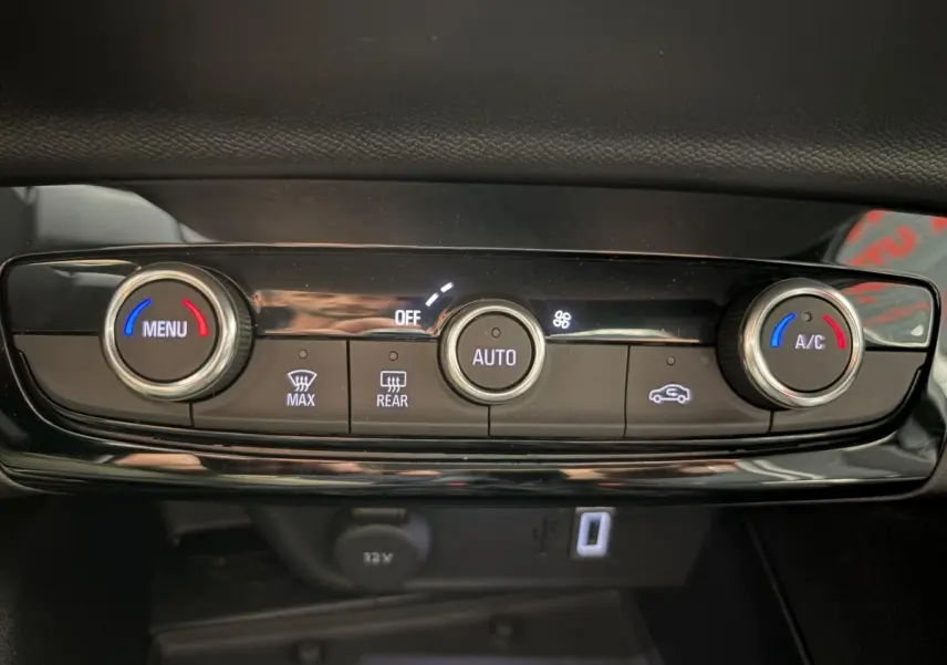 Gros plan sur la commande de climatisation automatique de la Opel Corsa gris clair, avec réglages température et ventilation.