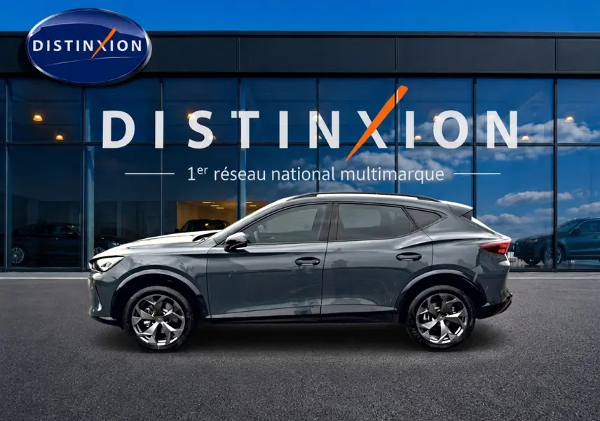 Vue latérale droite d'un CUPRA Formentor bleu fjord 2026 avec jantes 18 pouces devant une vitrine Distinxion.