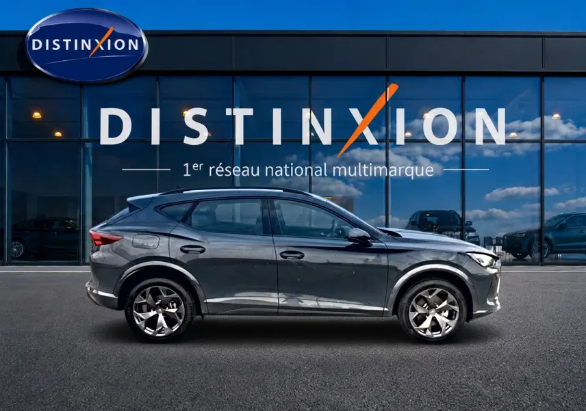 Vue latérale droite d'un CUPRA Formentor bleu fjord 2026 garé devant une vitrine avec logo Distinxion.