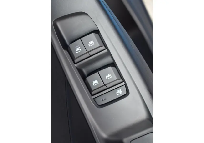 Gros plan sur les commandes de lève-vitres côté conducteur du MG3 1.5 HYBRID+ 195 LUXURY 2026, intérieur noir.