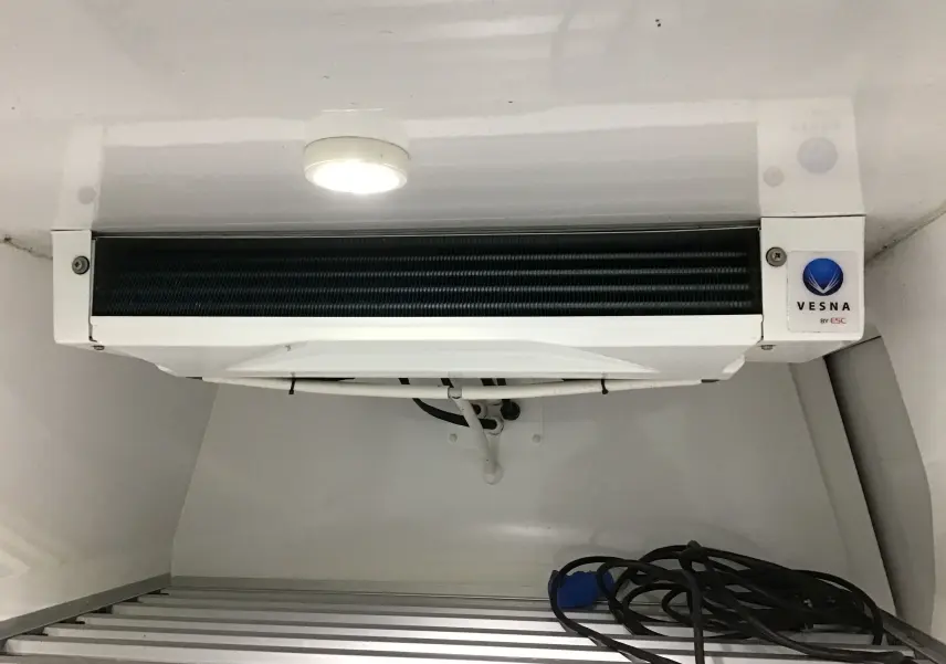 Gros plan sur le groupe frigorifique Vesna blanc installé dans la cellule réfrigérée du Renault Kangoo blanc.