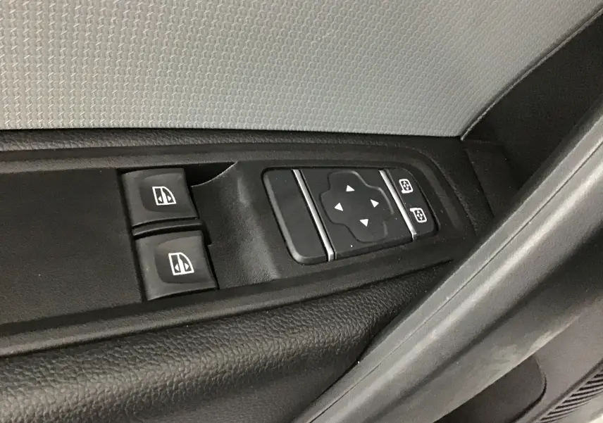 Commande des vitres électriques et réglage des rétroviseurs sur la porte côté conducteur d'un Renault Kangoo blanc.