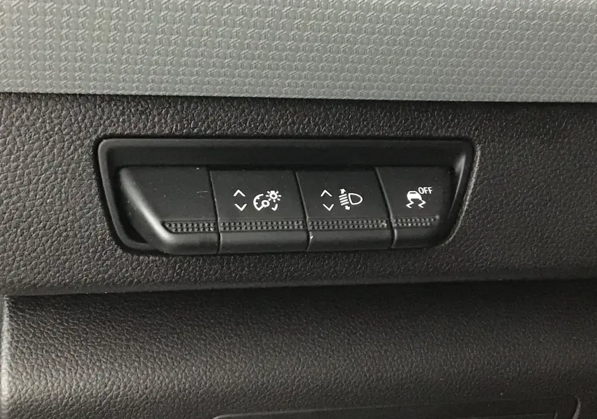 Boutons de réglage d'éclairage et contrôle de stabilité sur tableau de bord noir du Renault Kangoo blanc version frigo 2022.