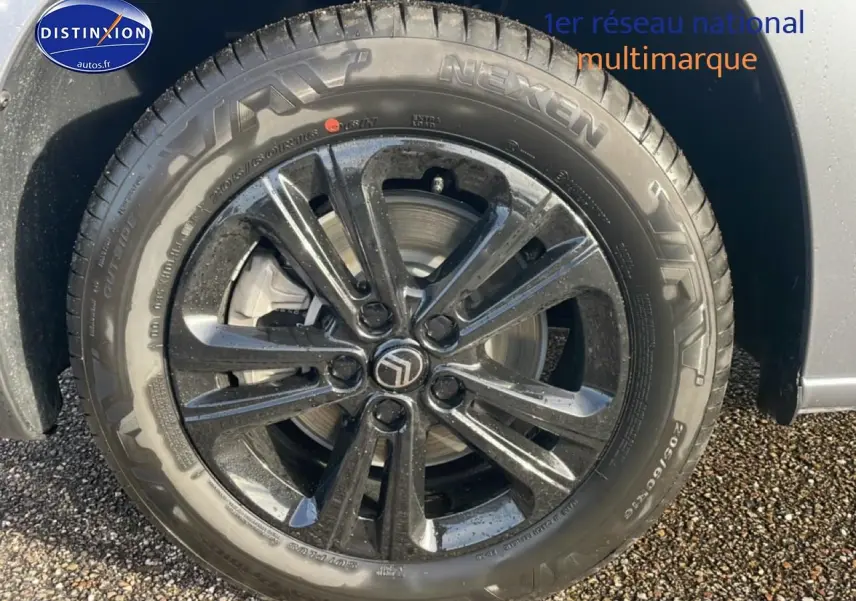 Gros plan sur la jante alu noire 16 pouces avec logo Citroën sur un Berlingo gris Artense.
